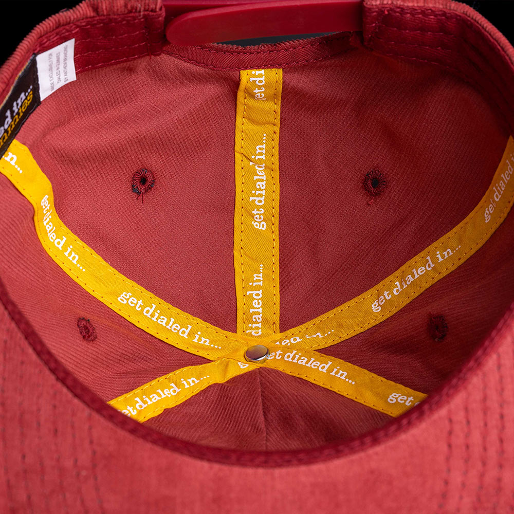 inside view of a maroon hat with "get dialed in..." custom stitching